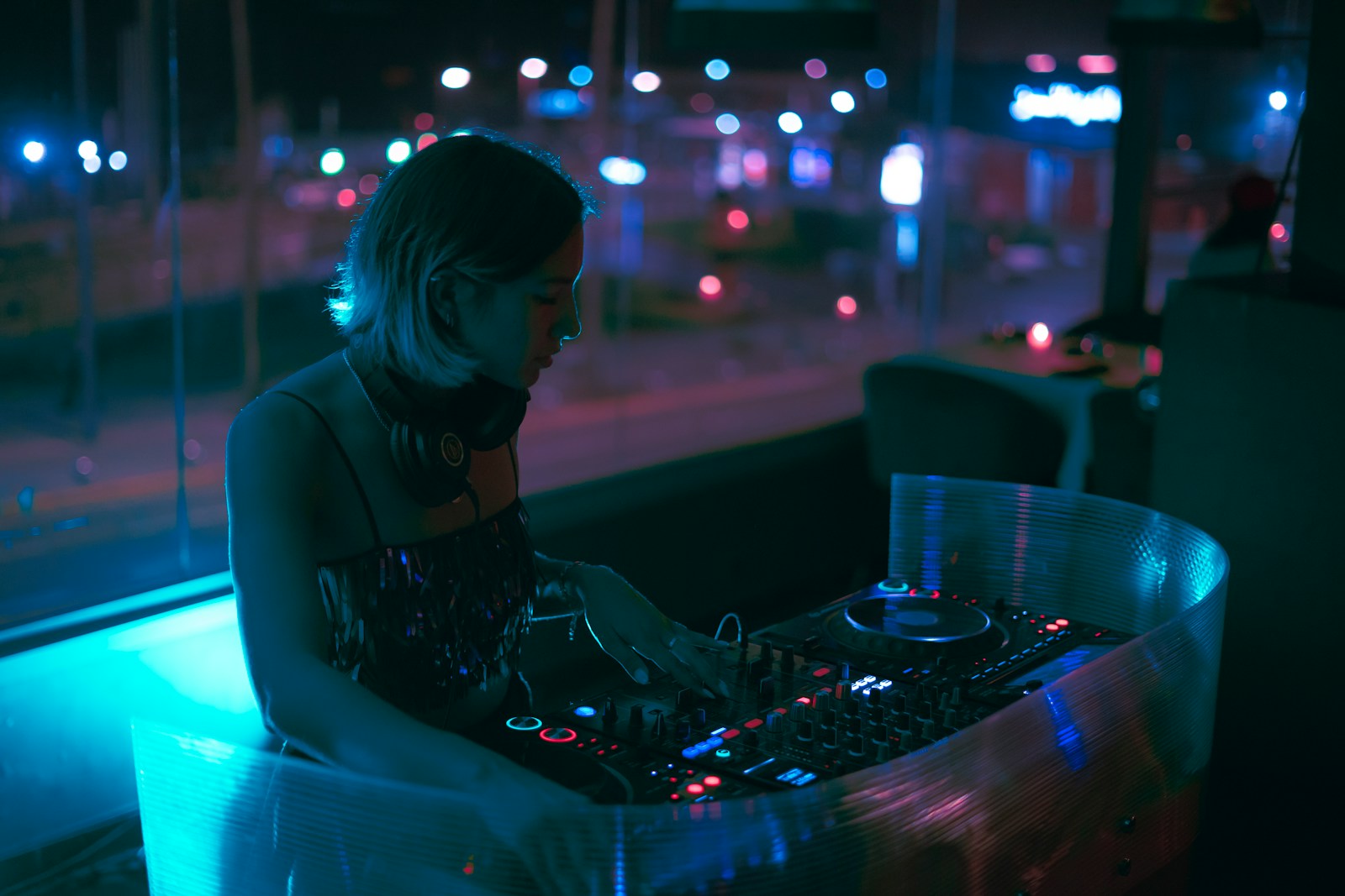 a woman sitting at a table with a dj controller