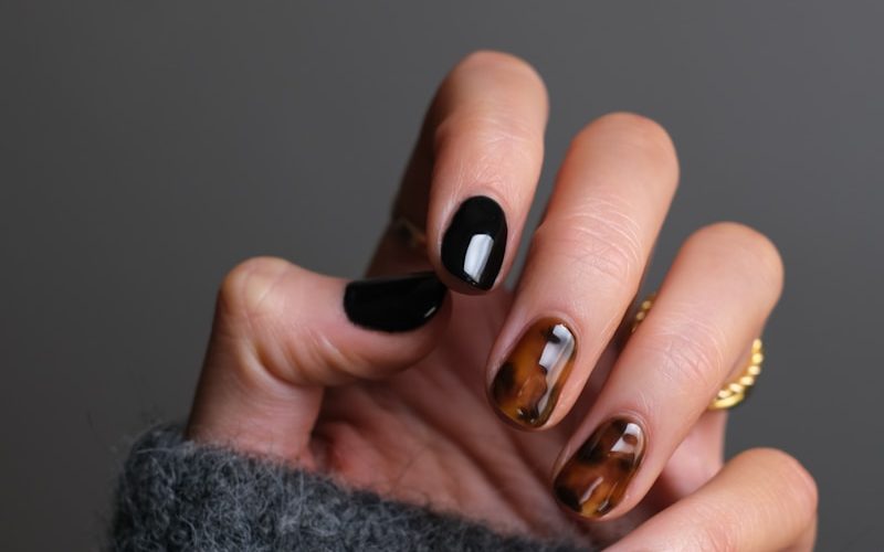 person wearing gold ring holding black textile