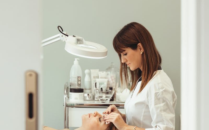 Beautician performs facial treatment in salon, enhancing skincare and relaxation.