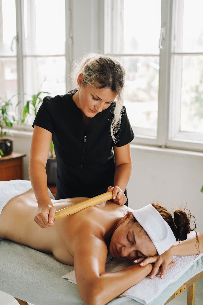 Woman receiving a relaxing bamboo massage at a wellness spa.