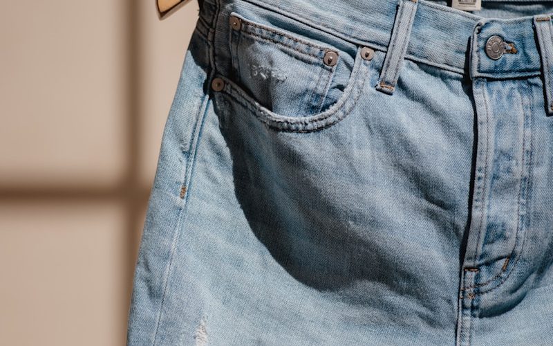blue denim jeans on brown clothes hanger
